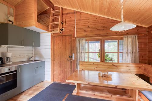 eine Küche mit einem Holztisch im Zimmer in der Unterkunft Pinetree Cottages Log cabin in Pyhäranta