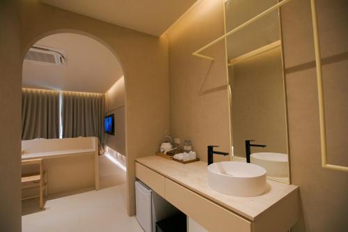 ein Badezimmer mit einem weißen Waschbecken und einer Badewanne in der Unterkunft Navakiri Boutique Resort Satun 