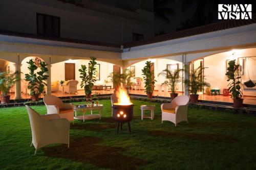 a courtyard with a fire pit in the grass at StayVista at Silver Oak Farm - Breakfast Included in Bangalore
