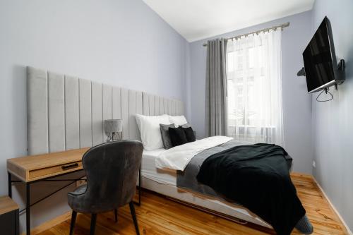 Schlafzimmer mit einem Bett, einem Schreibtisch und einem Stuhl in der Unterkunft Glamour Apartament - Centrum Poznania in Posen
