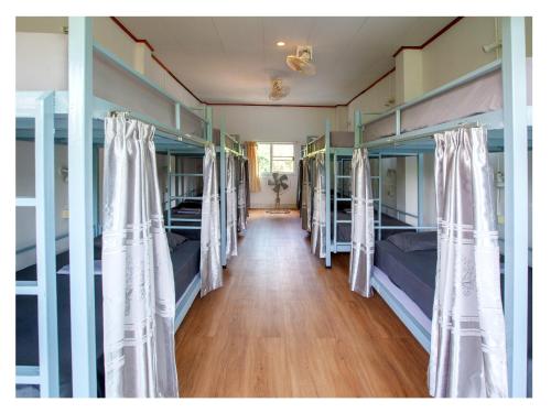 a hallway with four bunk beds in a room at Namhasin House in Koh Tao