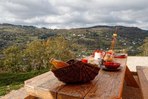 a picnic table with a basket of food on it at LE GRENIER DES MIOS in La Bresse