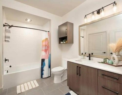 uma casa de banho com um chuveiro, um WC e um lavatório. em 8 minutes to Disneyland Sleeps 7 with 5 Beds 2 Bathrooms em Anaheim