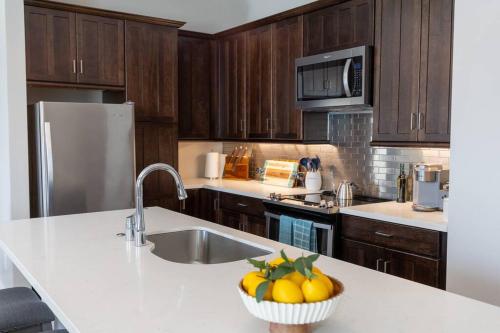a kitchen with a sink and a bowl of fruit on a counter at A Gem on the Strand in Galveston