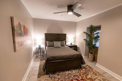 a bedroom with a bed and a ceiling fan at A Gem on the Strand in Galveston