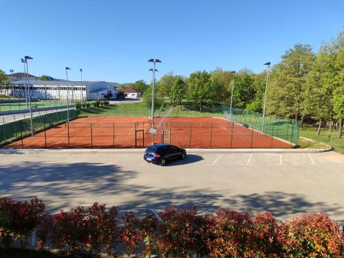 a car parked in a parking lot next to a tennis court at Dea sobe in Posušje