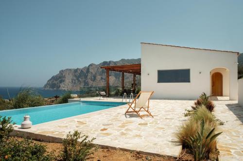 a villa with a swimming pool and a chair at Villa Thea in Mochlos