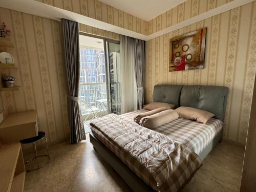 a bedroom with a bed in front of a window at Studio Apartment - Gold Coast PIK, Jakarta Utara in Jakarta