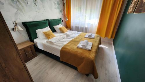 een kleine slaapkamer met een bed met handdoeken erop bij Apartament Garncarska in Elblag