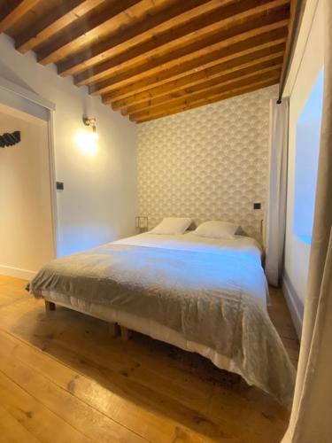 une chambre avec un grand lit avec un plafond en bois dans l'établissement Appartement Clermont-Fd jaude 1, à Clermont-Ferrand