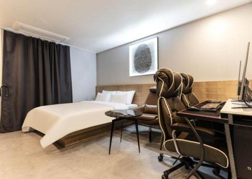 een slaapkamer met een bed en een bureau met een computer bij Carlton Hotel Bupyeong in Incheon