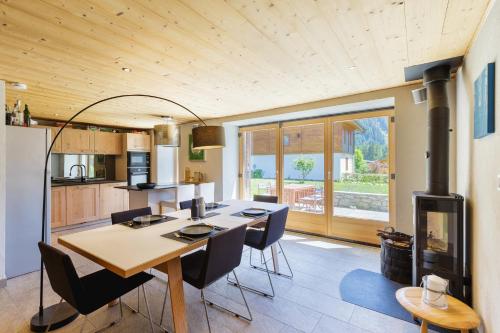a kitchen and dining room with a table and chairs at Chalet Plein Centre - Savoyard Moderne - Happy Rentals in Chamonix