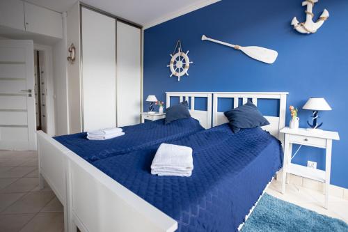 1 dormitorio azul con 1 cama grande con sábanas azules en Międzymorze 1024, en Jurata