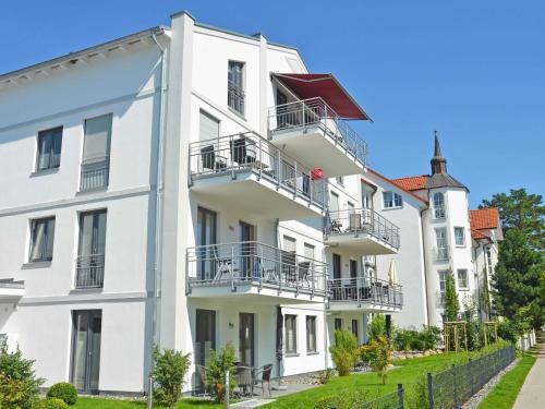 a white building with balconies on a street at Residenz Margarete - Apt. 1.3 in Binz