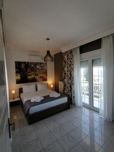 a bedroom with a bed and a large window at Villa Eleonas in Skala Kallirakhis