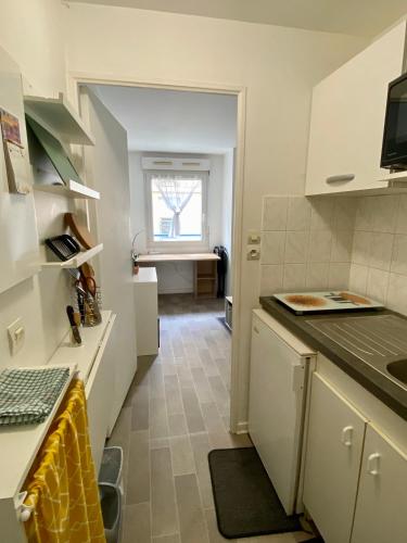 a kitchen with white cabinets and a counter top at Solo ou Duo serré in Le Kremlin-Bicêtre