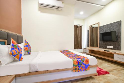 a bedroom with a bed and a flat screen tv at FabHotel SS Blue in Indore