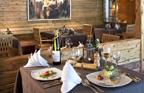 a table with two plates of food and a bottle of wine at LANIG Hotel Resort&Spa - Wellness und Feinschmeckerhotel - family owned and managed in Oberjoch