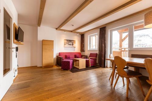 a living room with a table and a couch at Almresort Gartnerkofel Nassfeld in Sonnenalpe Nassfeld