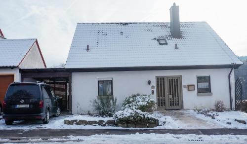 a white house with a van parked in front of it at Ferienhaus Ebern-Sölln in Ebern