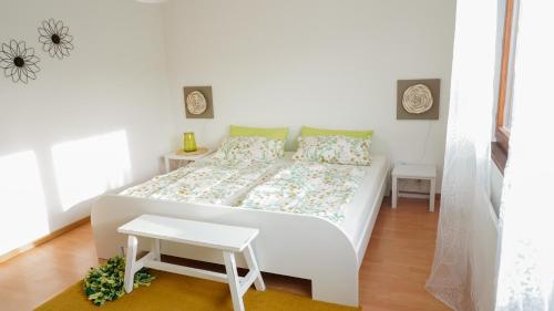 Un pequeño dormitorio con una cama blanca y una mesa en Ferienhaus Taeffner en Ebern