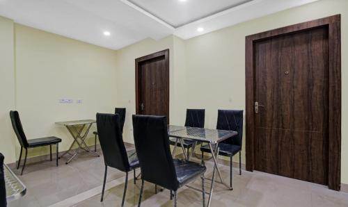a dining room with a table and chairs and a door at Hotel Park Central in Kolkata