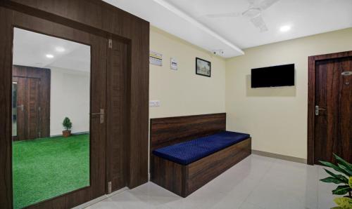 a waiting room with a door and a bench and a tv at Hotel Park Central in Kolkata