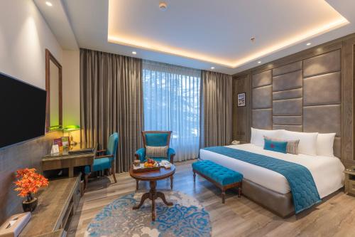a hotel room with a bed and a desk at WelcomHeritage Elysium Resort & Spa in Shimla