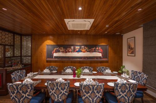 a dining room with a table with chairs and a cake at WelcomHeritage Elysium Resort & Spa in Shimla