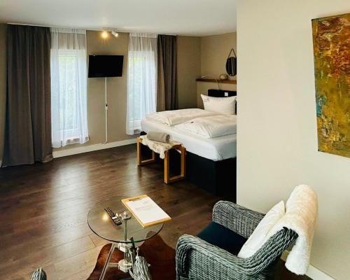 a bedroom with a bed and a table and chairs at Hotel Inselhof in Malchow