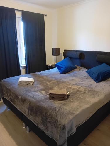 1 dormitorio con 1 cama grande con almohadas azules en Lägenhet på andra våningen, en Hallabro