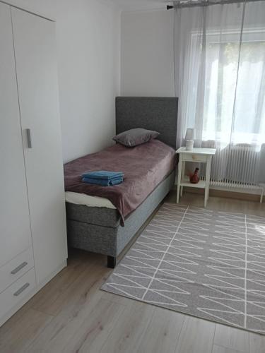 1 dormitorio con cama, ventana y alfombra en Lägenhet på andra våningen, en Hallabro