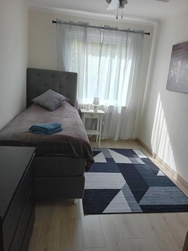1 dormitorio con cama y alfombra en el suelo en Lägenhet på andra våningen, en Hallabro