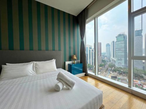 um quarto com uma cama branca e uma grande janela em Luxe Suites at Platinum KLCC em Kuala Lumpur