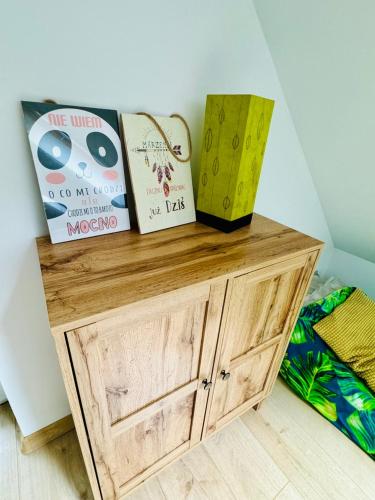 a wooden cabinet with books on top of it at Uchankowo pod Łowiczem in Łyszkowice