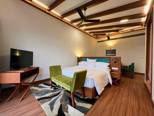 Schlafzimmer mit einem Bett, einem Schreibtisch und einem TV in der Unterkunft Welcomhotel By ITC Hotels, Jim Corbett in Marchula