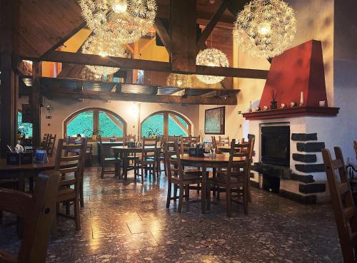 a dining room with tables and chairs and a fireplace at Hotel Lesana in Špindlerův Mlýn