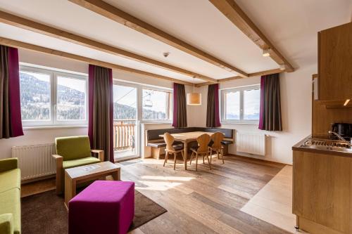 a kitchen and dining room with a table and chairs at Almresort Gartnerkofel Nassfeld in Sonnenalpe Nassfeld