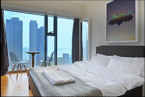 ein Schlafzimmer mit einem weißen Bett und einem großen Fenster in der Unterkunft Asuncion Apartment for Rent 
