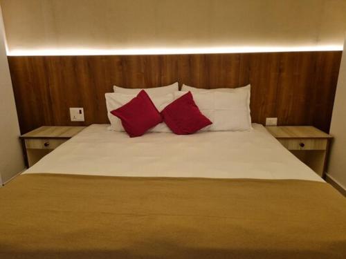 a bed with two red pillows on top of it at TANTRA BOUTIQUE HOTEL in Imphal