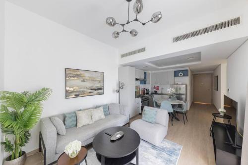 Comfortable 2bd Apartment Next To Metro & Mall في دبي: غرفة معيشة مع أريكة وطاولة