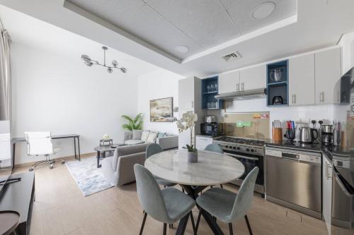 a kitchen and living room with a table and chairs at Comfortable 2bd Apartment Next To Metro & Mall in Dubai