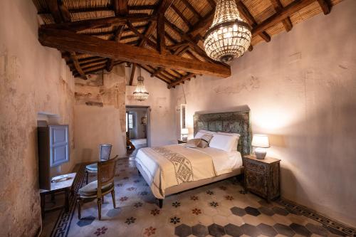 a bedroom with a bed and a desk and a television at Palazzo Boyl 1840 in Cagliari