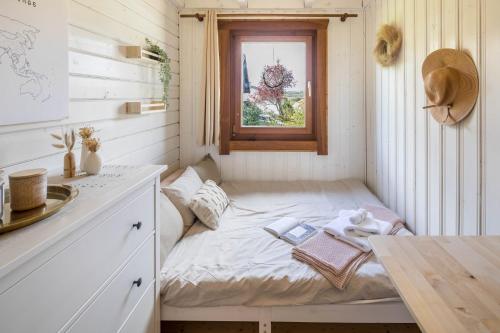 a small bed in a small room with a window at Ferienhaus - Almhütte No2 in Ulrichstein