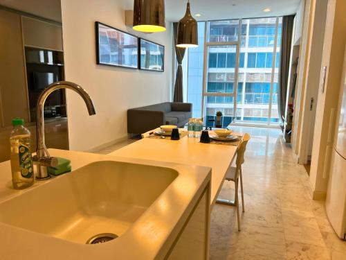 uma cozinha com um lavatório e uma sala de estar em Luxe Suites at Platinum KLCC em Kuala Lumpur