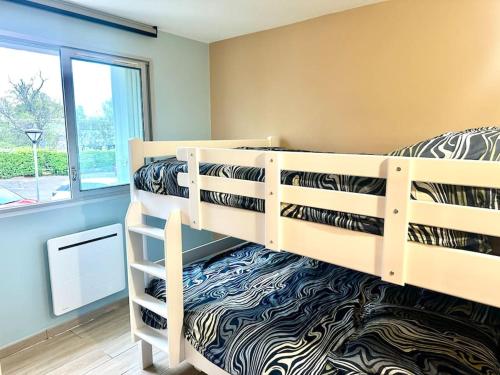 une chambre avec deux lits superposés et une fenêtre dans l'établissement Appartement en bord de mer, à La Grande Motte