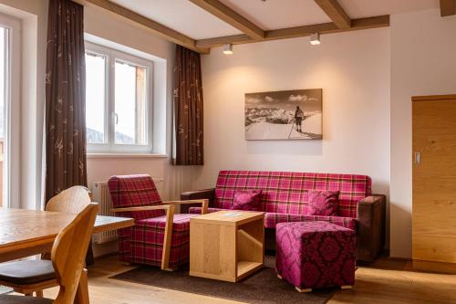 a living room with a couch and a table at Almresort Gartnerkofel Nassfeld in Sonnenalpe Nassfeld