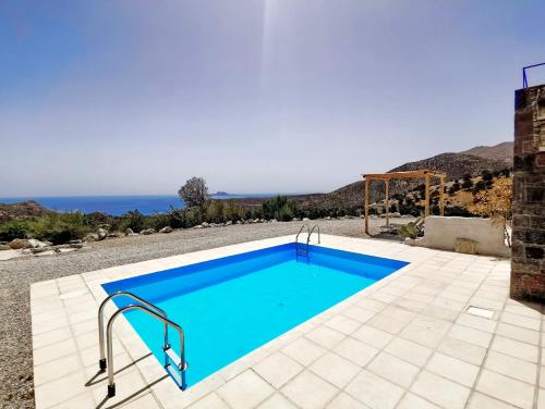 een blauw zwembad met de oceaan op de achtergrond bij Magical Crete Villa| Villa Giorgos | Beautiful Sea & Landmark views | Terrace & Private Pool | 2 Bedrooms | Agia Galini in Agia Galini