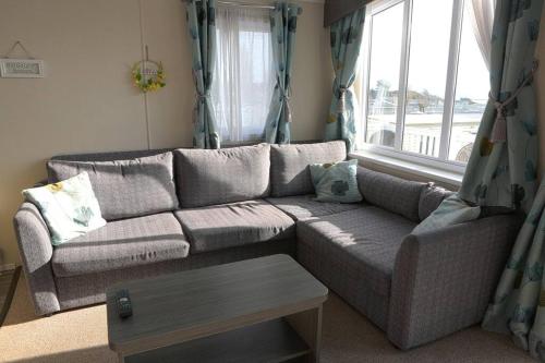 a living room with a couch and a window at Holiday home with Panoramic Sea Views in Lytchett Minster