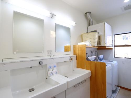 a bathroom with two sinks and a mirror at Shiroyamasou in Asahi
